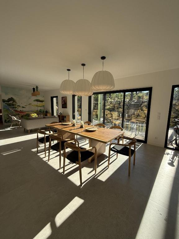 une salle à manger avec une table et des chaises en bois dans l'établissement Villa d'exception à Lacanau océan, à Lacanau