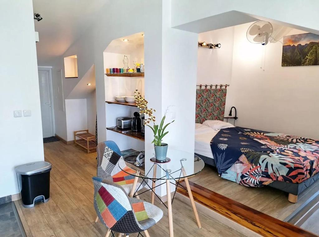 a bedroom with a bed and a table and a chair at Studio cosy avec vue sur mer à Saint-Leu, 31 m² in Saint-Leu