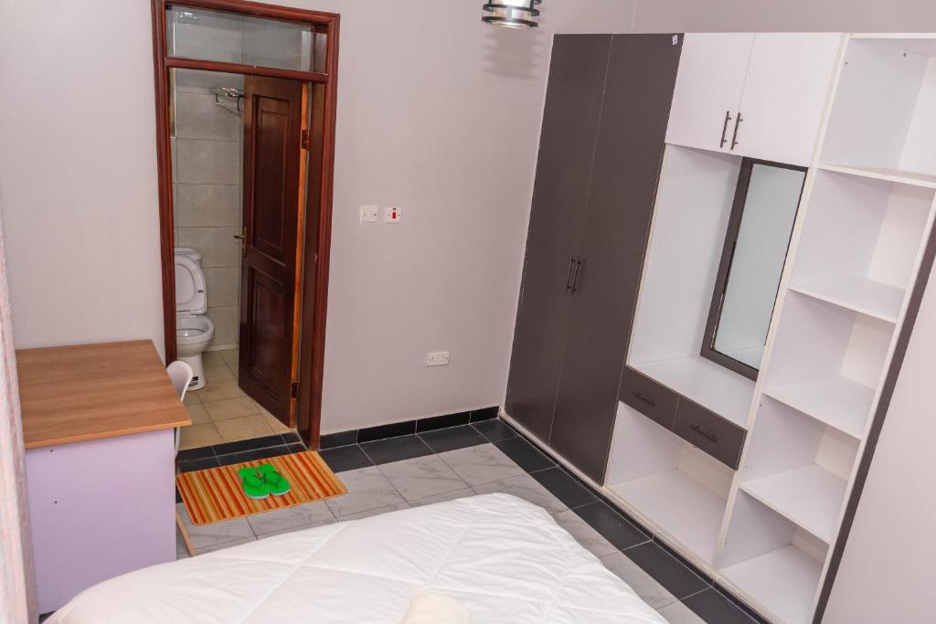 a small room with a bed and a bathroom at Urban Bliss Residence in Bungoma