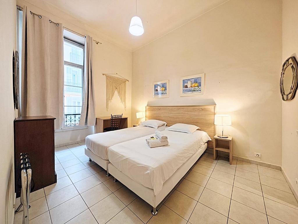 a bedroom with a large white bed and a window at Viva Riviera Residence Marina Croisette in Cannes