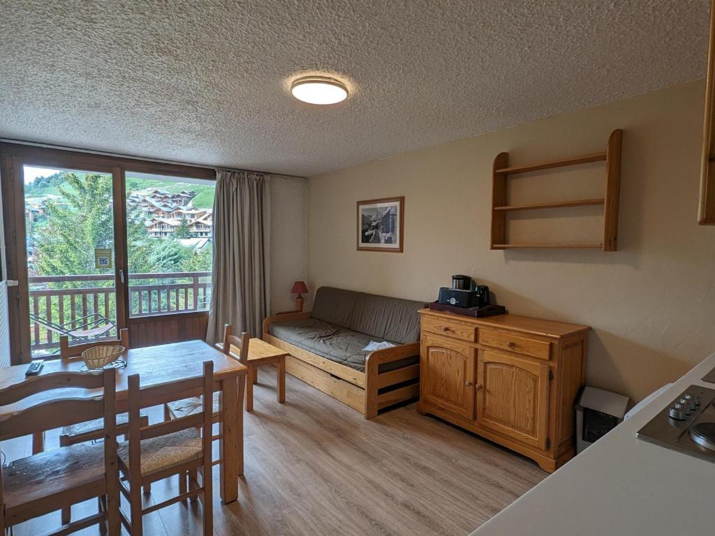 un salon avec un canapé et une table dans l'établissement Studio fonctionnel avec balcon, au pied des pistes, animaux admis - FR-1-811-32, à Les Deux Alpes
