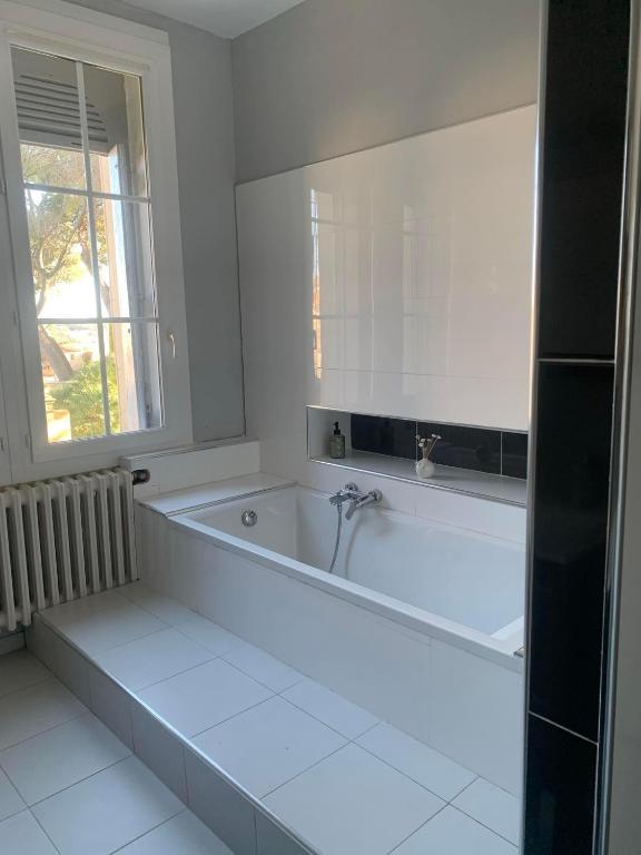 a white bath tub in a bathroom with a window at Château Sainte Colombe in Saint-Geniès-des-Mourgues