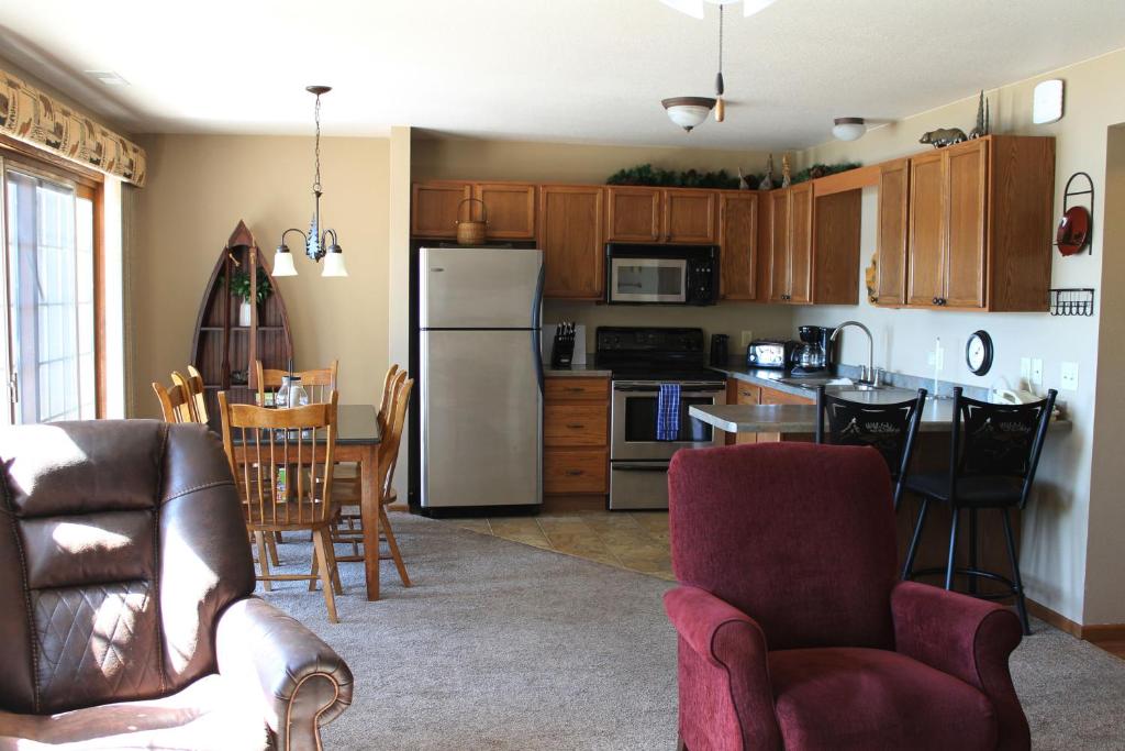 Una cocina con refrigerador y una mesa y sillas. en 2 bedroom accessible condo #112 Wild Eagle Lodge, en Eagle River