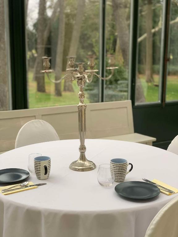 a table with a white table cloth and a candlesticks at Château Sainte Colombe in Saint-Geniès-des-Mourgues