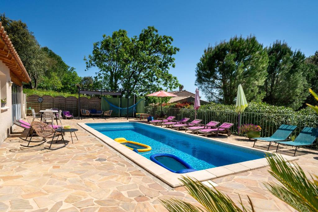 une piscine avec des chaises violettes et une clôture dans l'établissement Résidence Au Brin d'Olivier, à Saint-Martin-dʼArdèche