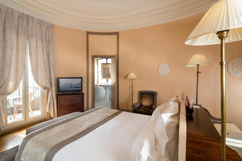 a bedroom with a large bed and a television at Le Cavendish in Cannes