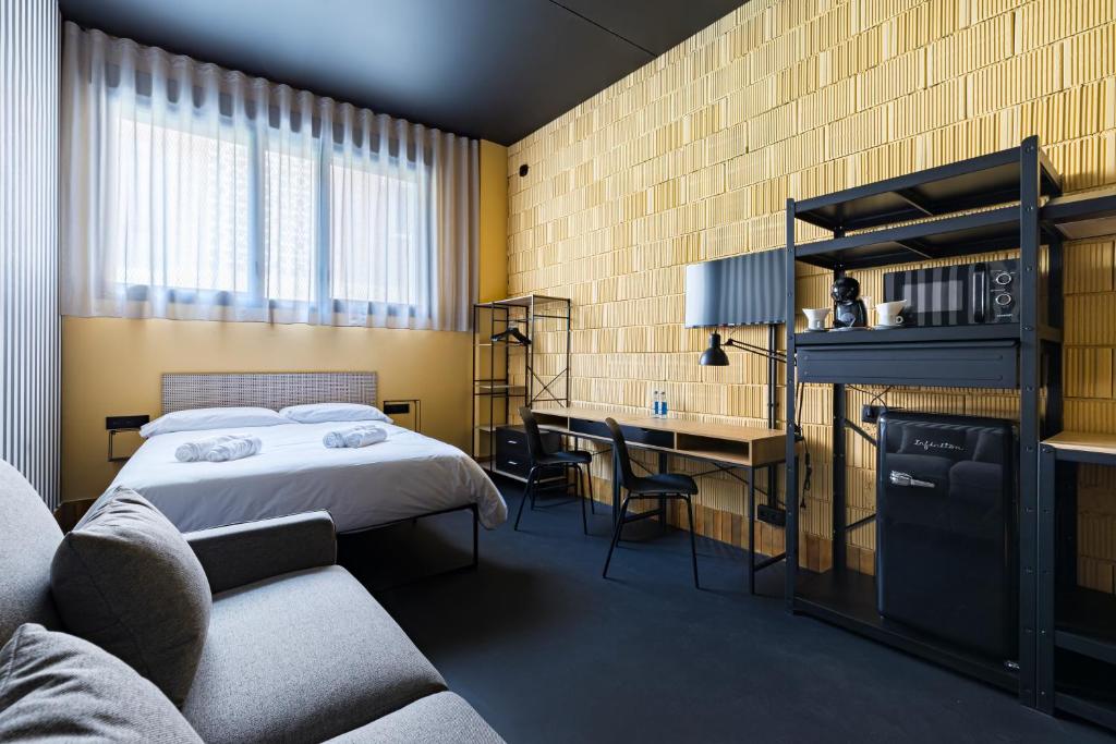 a bedroom with a bed and a desk and a chair at Apartamentos HEY U in Murcia