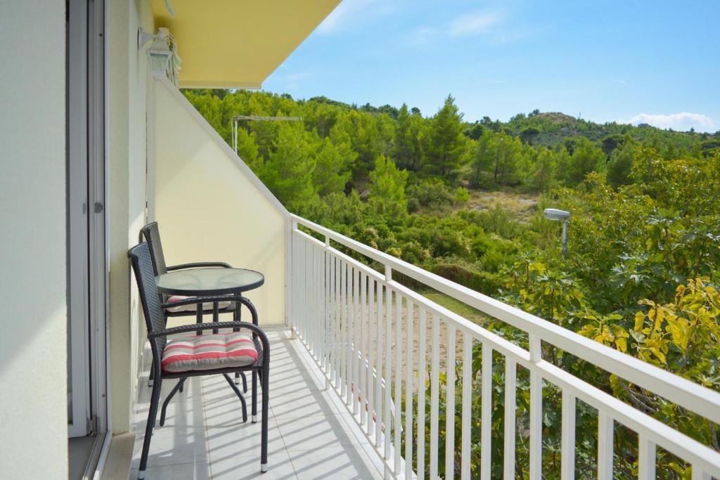 a balcony with two chairs and a view of the forest at Rosemary Apartment in Promajna
