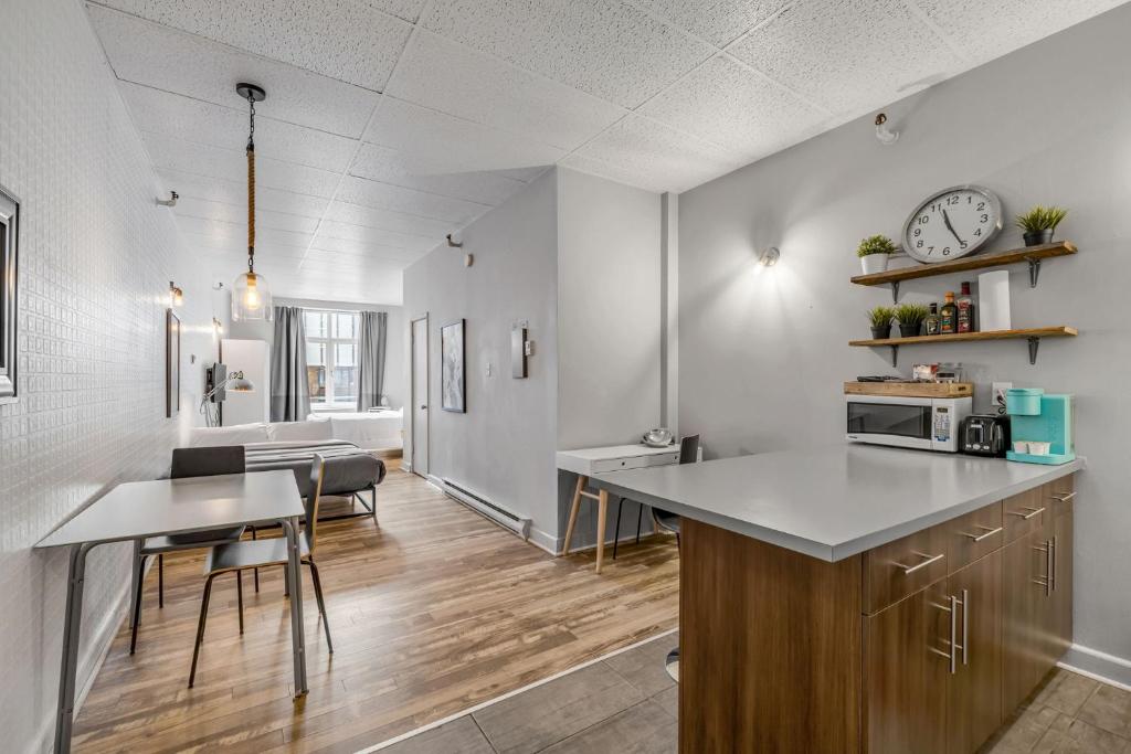 a kitchen and dining room with a table and a clock at Initial 303 Québec in Quebec City