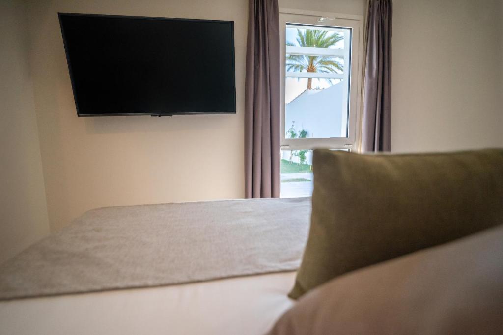 Televízia a/alebo spoločenská miestnosť v ubytovaní HL Miraflor Suites Hotel