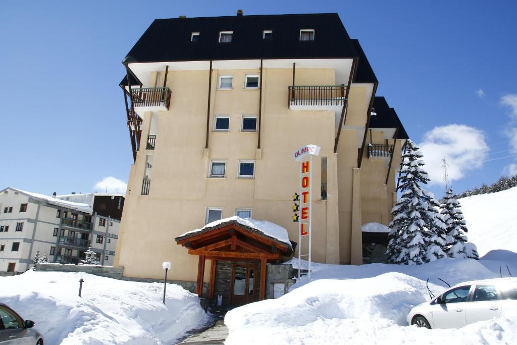a building in the snow with a pile of snow at Hotel Olimpic in Sestriere
