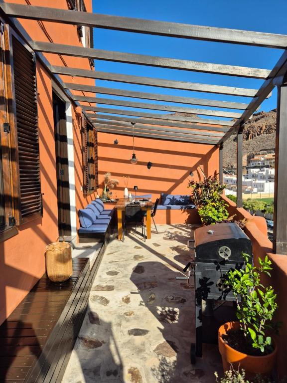 a patio with a table and chairs on a building at Casa Moni con Vistas al Mar in Playa de Santiago