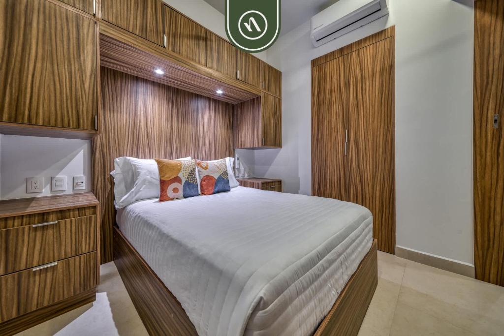 a bedroom with a large bed with a wooden wall at Brand New 1 BR Condo - Pool - Jacuzzi - Gym in Nuevo Nayarit