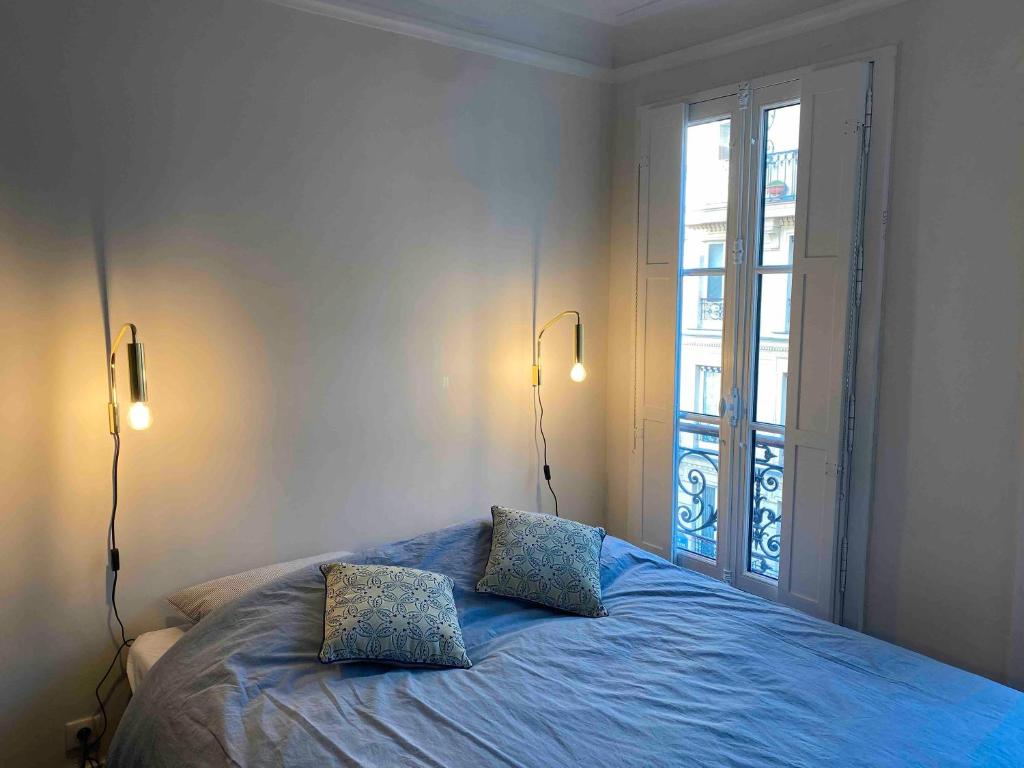 a bedroom with a bed with two pillows on it at Superbe appartement quartier latin in Paris