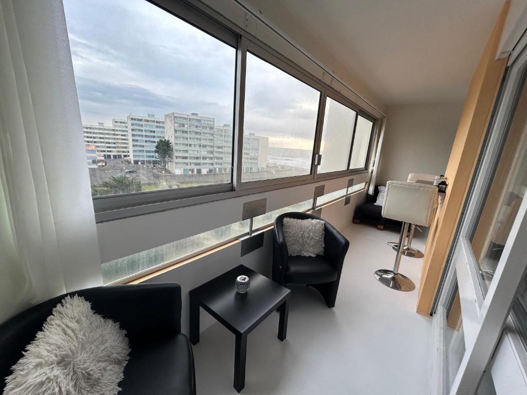 un salon avec deux chaises et une grande fenêtre dans l'établissement Appart T2 magnifique vu océan, à Saint-Hilaire-de-Riez