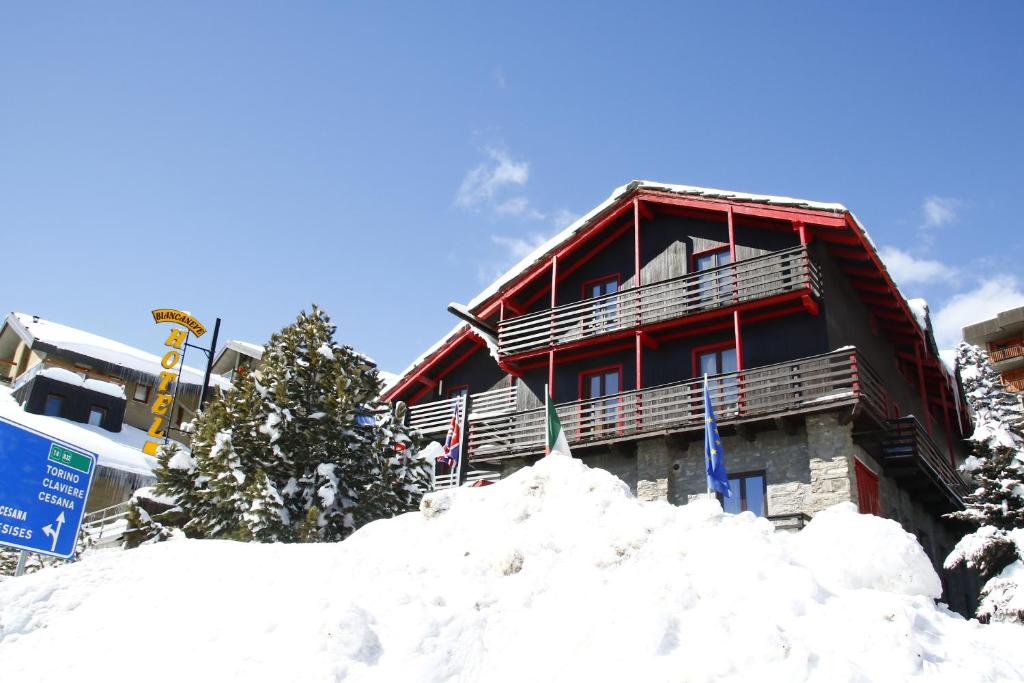 a building with a pile of snow in front of it at Hotel Biancaneve in Sestriere