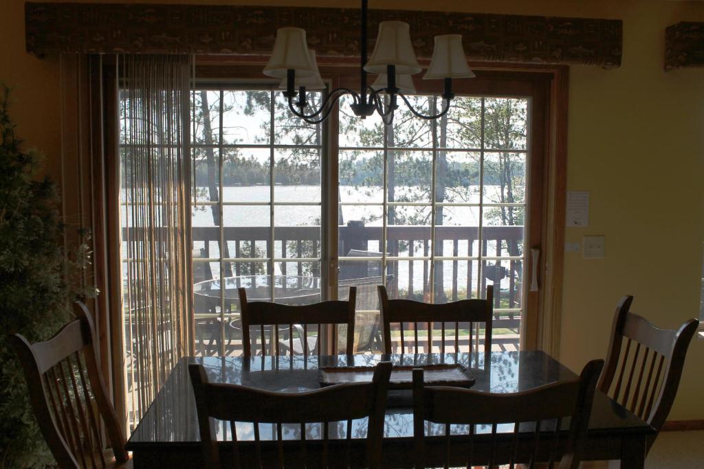 a dining room table with chairs and a large window at Duck Lake 2 bedroom condo at Wild Eagle Lodge, #206 in Eagle River