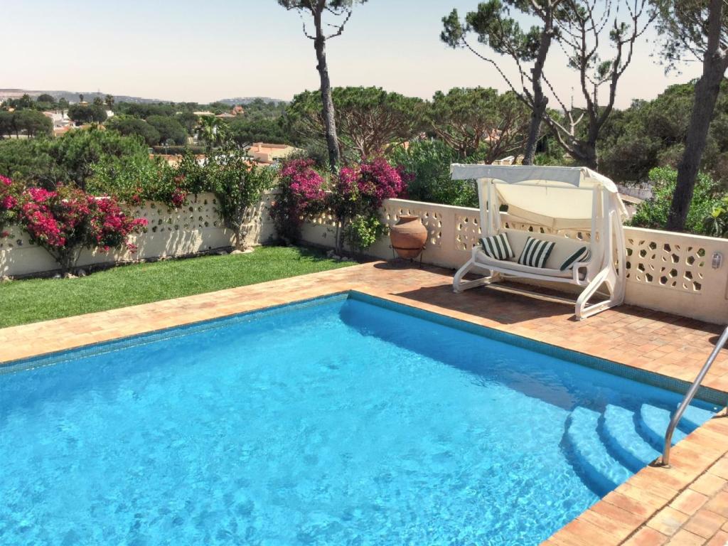 a swimming pool with a deck and a chair in a yard at Elegant Villa in Vilamoura with Private Pool in Vilamoura