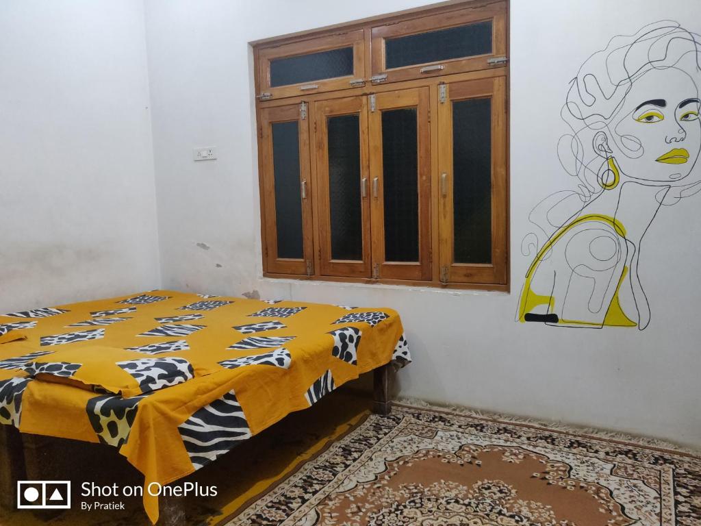Un dormitorio con una cama y un cuadro en la pared. en Shobha casa 2, en Prayagraj