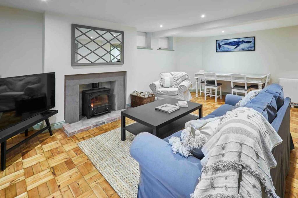 Una sala de estar con un sofá azul y una chimenea. en Host & Stay - St Mary's Riverside, en Whitby