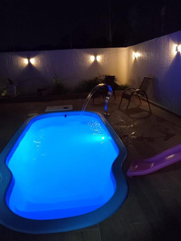 a blue lighted bath tub in a room at night at Suíte da piscina in Frederico Westphalen