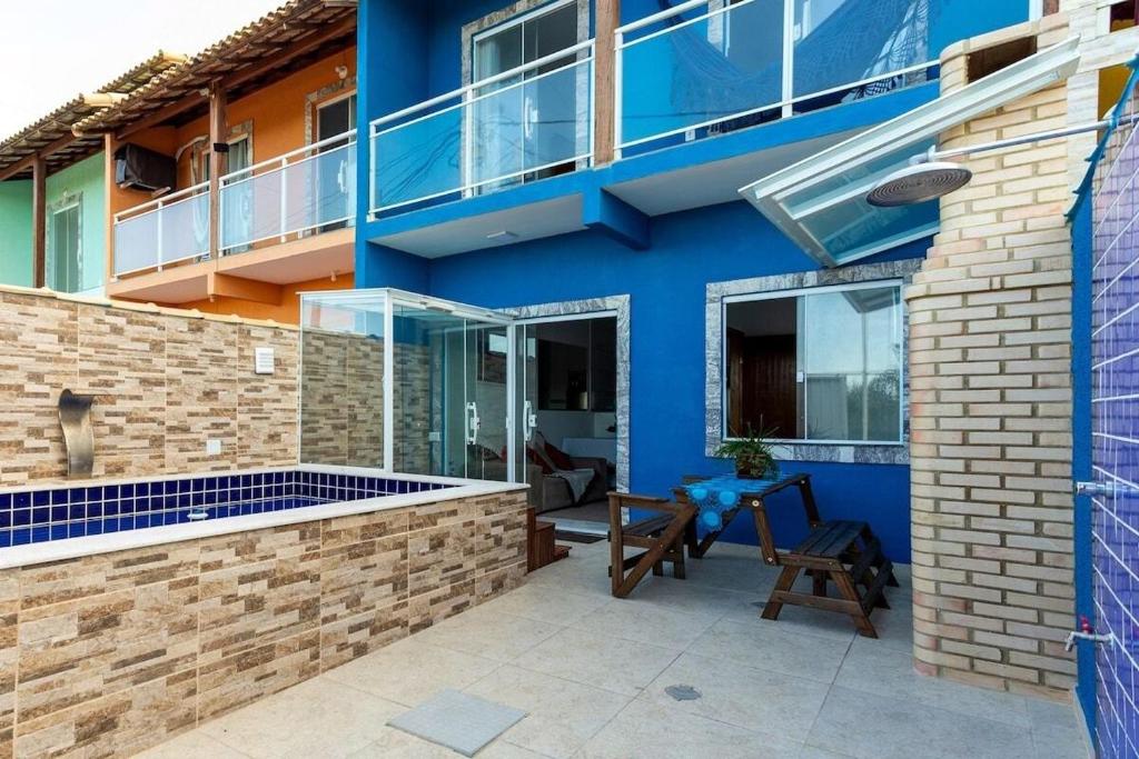 un bâtiment bleu avec un patio devant dans l'établissement Unamar, conforto em frente a praia!, à Cabo Frio