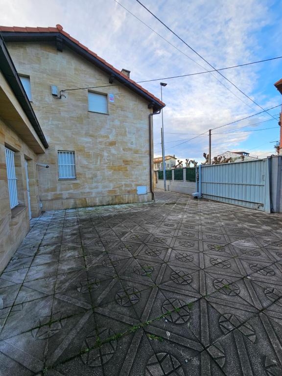 un edificio de ladrillo con suelo de baldosa delante de él en TATI HOMES - Caleruco 50, en Santander