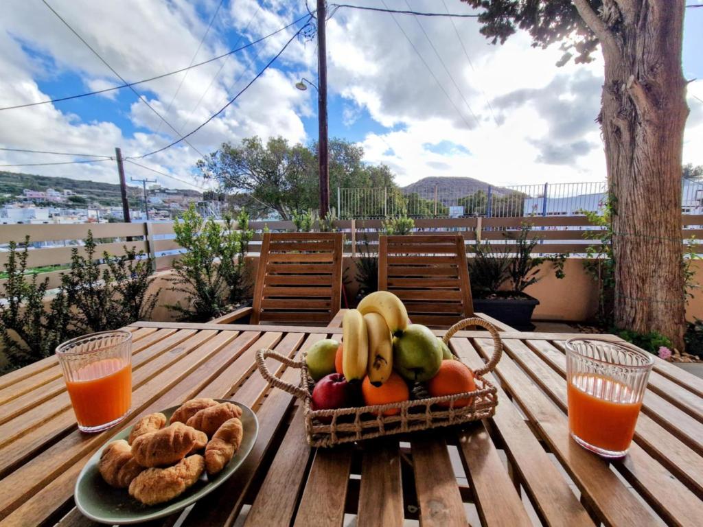 una cesta de fruta y pan en una mesa de madera en Mea Casa Comfort Home, en Pitsidia