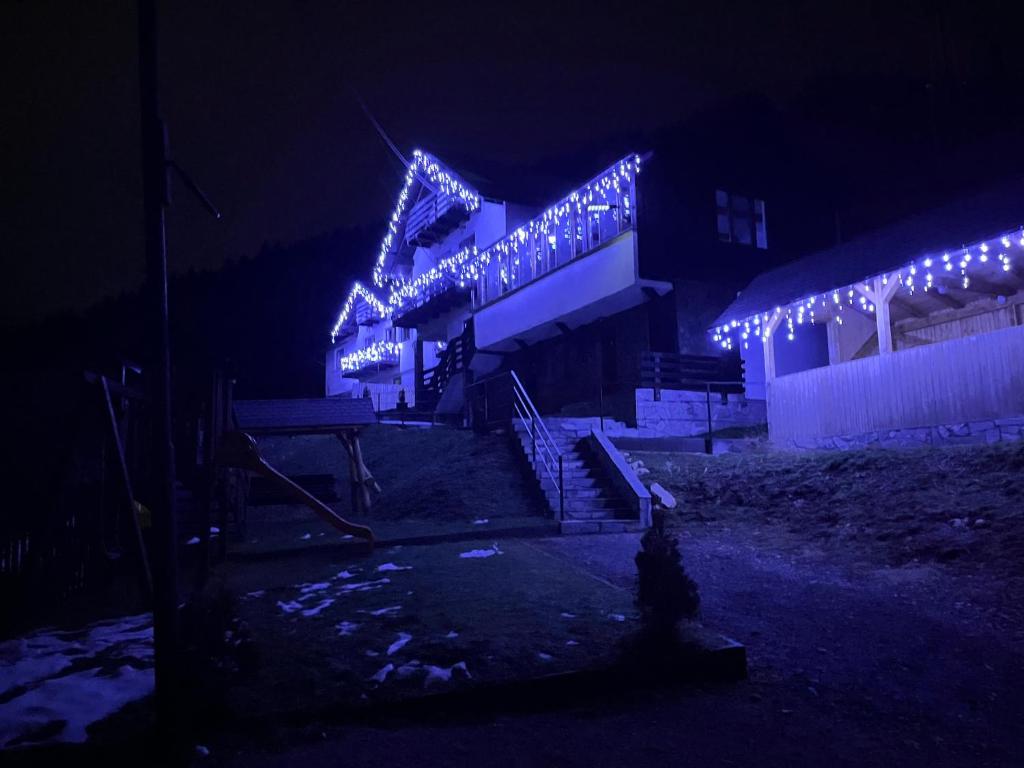a building with christmas lights on it at night at Casa Dani&Moni in Moieciu de Sus