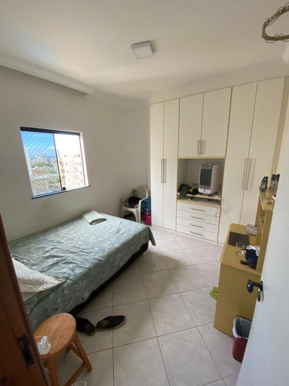 Un pequeño dormitorio con una cama y una cocina. en Residencial Candeias, en Vitória da Conquista