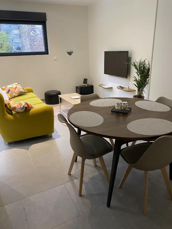 - un salon avec une table, des chaises et une télévision dans l'établissement Maison individuelle avec terrasse et parking, à Sains-lès-Marquion