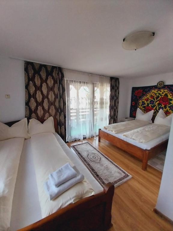 Postel nebo postele na pokoji v ubytování Pensiunea Rustic Oncesti