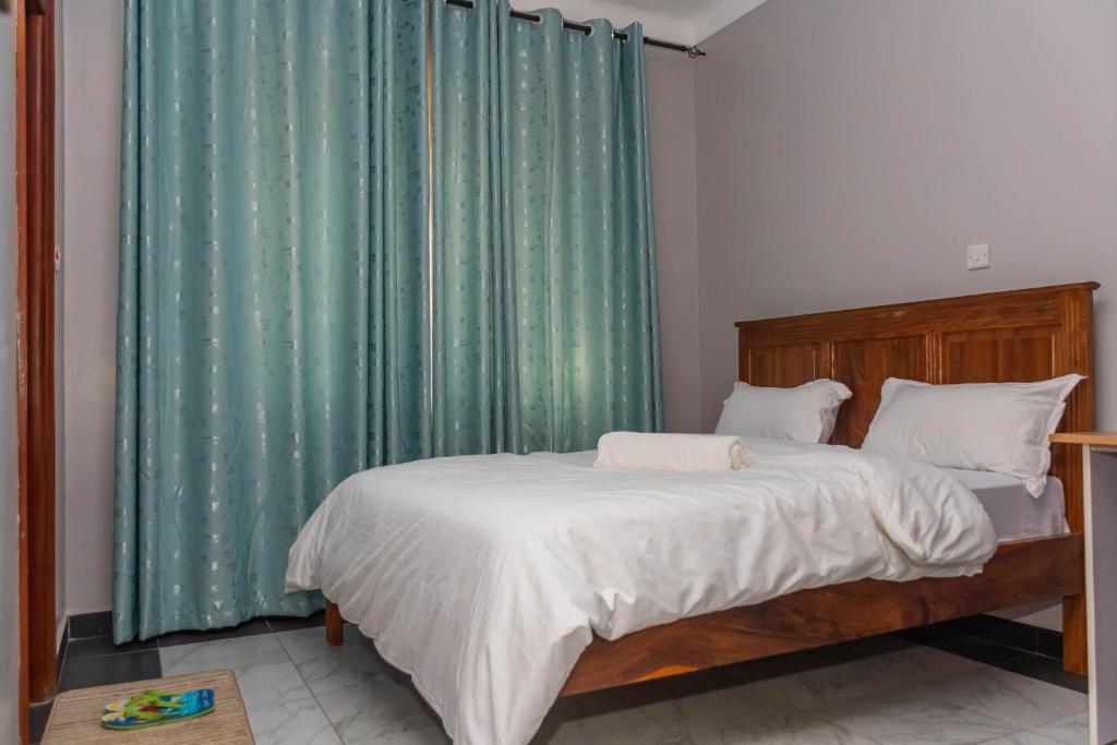 a bedroom with a bed with a green curtain at Urban Bliss Residence in Bungoma