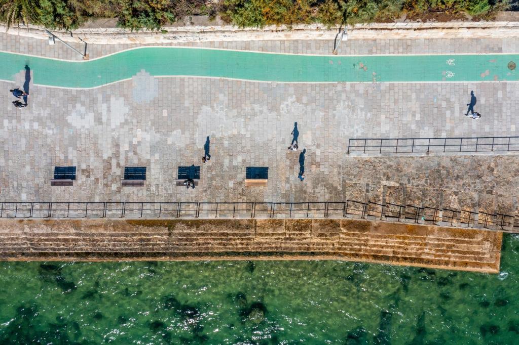 a group of people standing on a pier in the water at Hotel Cascais Miragem Health & Spa in Cascais