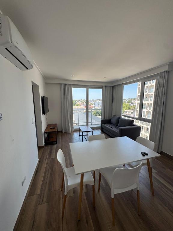 a living room with a white table and a couch at Departamento céntrico con cochera y piscina Paz 341 in Tandil