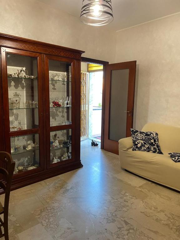 a living room with a couch and a glass cabinet at APT Via Calabria 6da Francesca in Marina di Monasterace