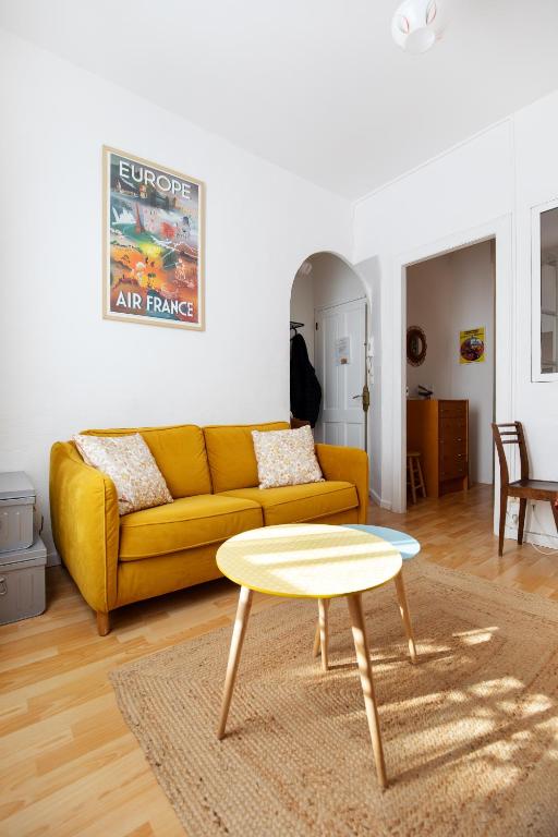 un salon avec un canapé jaune et une table dans l'établissement Charmant Apt proche du parc Simone Veil, à Sète