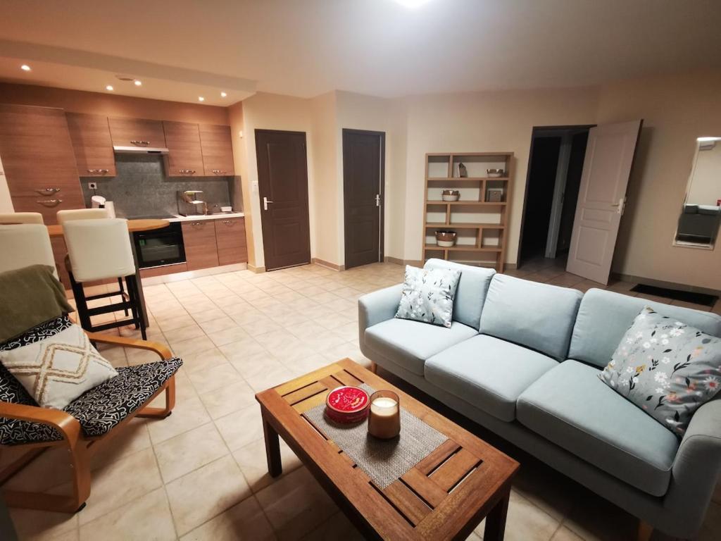 un salon avec un canapé bleu et une table dans l'établissement Votre petite maison de vacances, à Saint-Bauzille-de-Putois