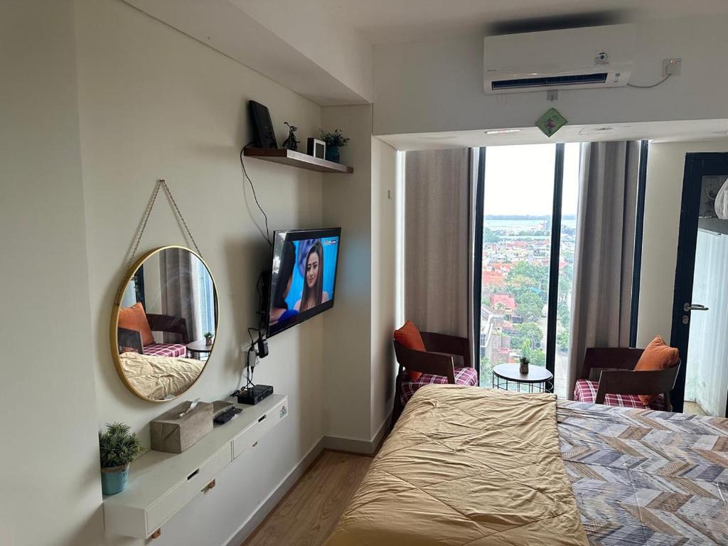 a bedroom with a bed and a mirror and a window at Meisterstad Pollux Habibie Apartment Batam Studio805 in Batam Center