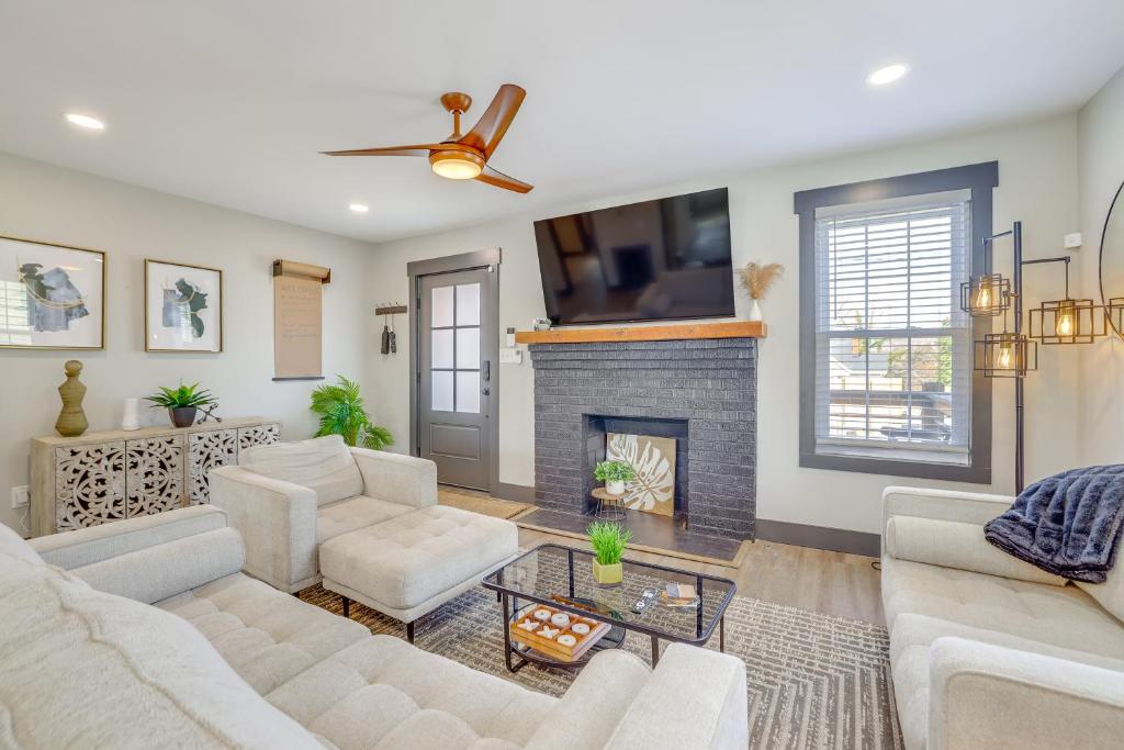 a living room with white furniture and a fireplace at 4 Mi to Liberty Bridge Greenville Getaway with Deck in Greenville