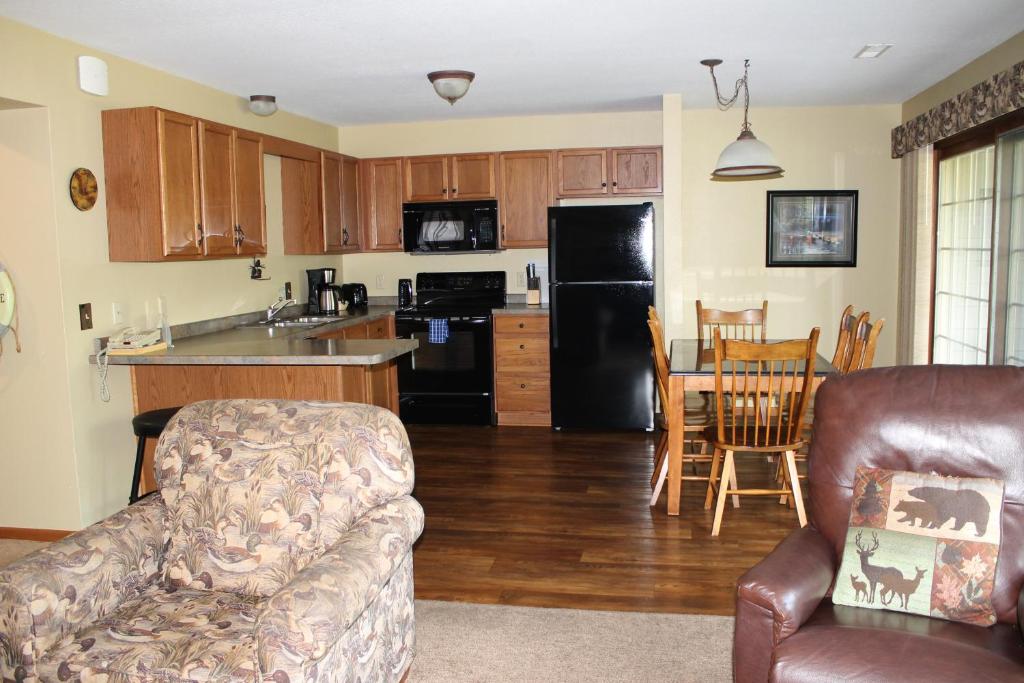 a kitchen and living room with a couch and a table at 2 Bedroom Condo at Wild Eagle Lodge in Eagle River