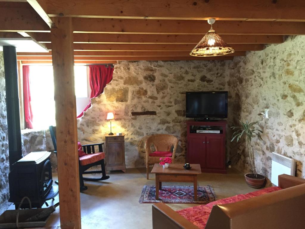 un salon avec un mur en pierre dans l'établissement gite des prés martin, à Chaille sous les Ormeaux