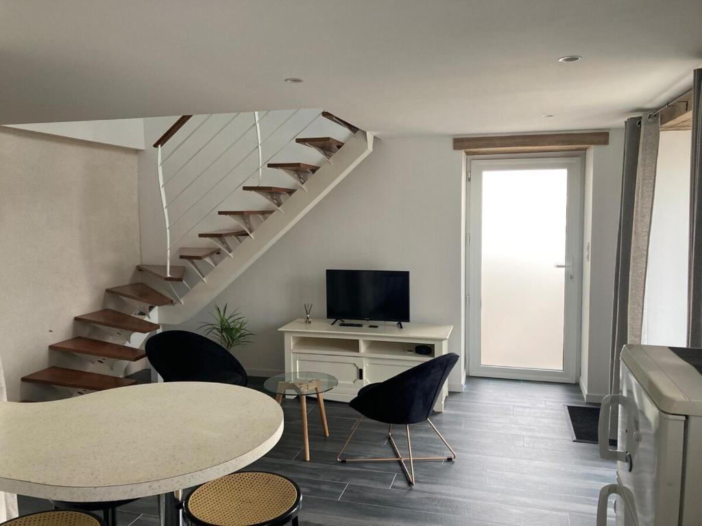 - un salon avec un escalier, une table et des chaises dans l'établissement Gite sur ferme équestre, à Pouldreuzic