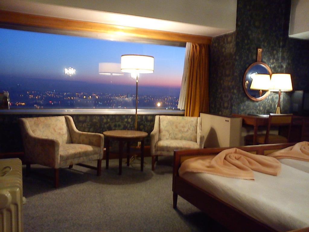 a living room filled with furniture and a large window at Hotel Miradouro in Porto