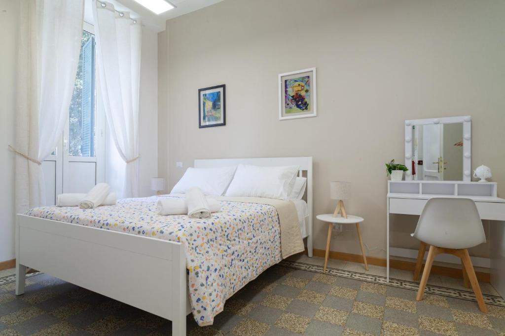 a white bedroom with a bed and a window at Studio Piramide in Rome