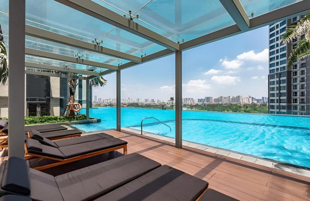 a large swimming pool with a view of a building at The Luxe Nest Riverside - Vinhome Landmark 81 in Ho Chi Minh City