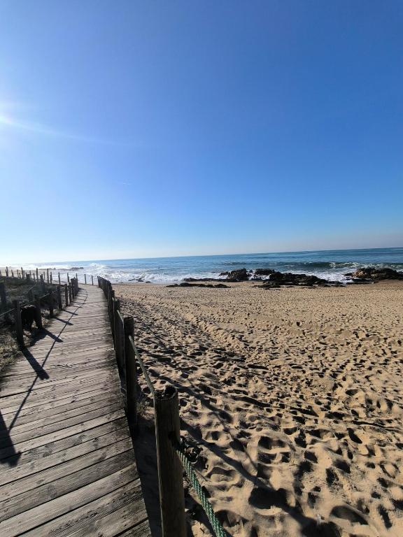 a wooden boardwalk on a beach with the ocean at Vila Mar Beach House in Arcozelo