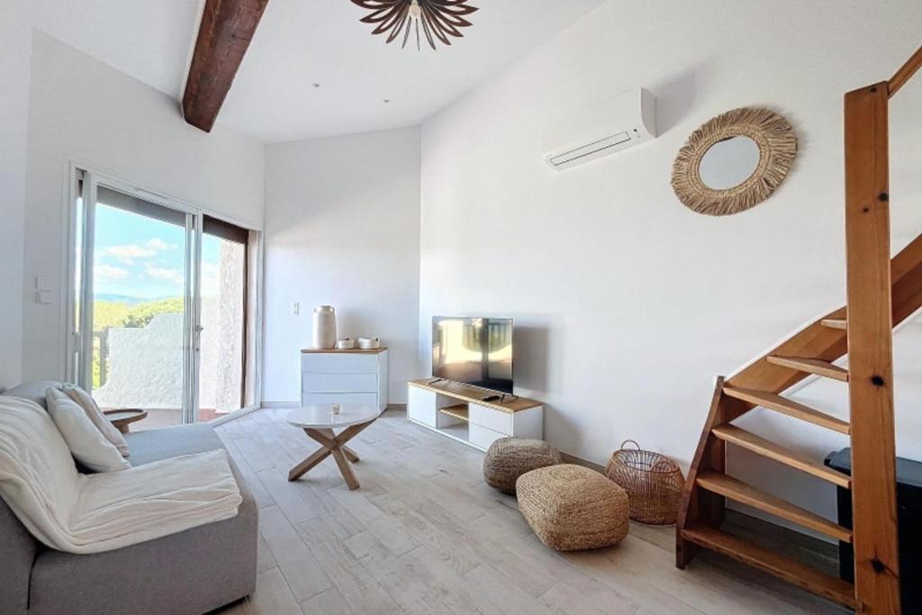 un salon avec un escalier et un canapé dans l'établissement New 2025 Haut de villa 2 chambres vue mer climatisé à 300 mètres de la mer, à Pietrosella