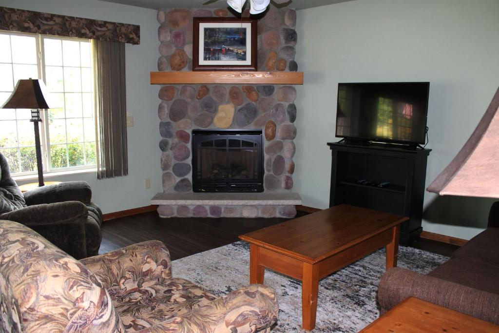 a living room with a fireplace and a television at 2 bedroom condo at Wild Eagle Lodge, #133 in Eagle River