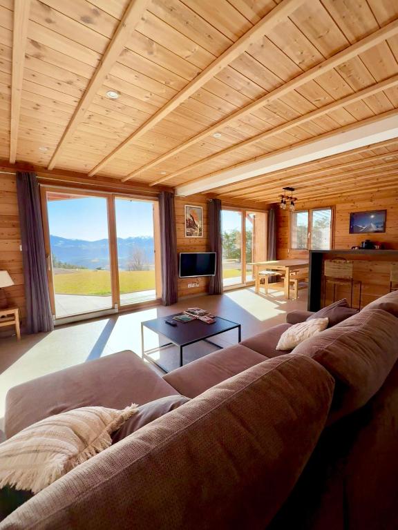 un grand salon avec un canapé et une table dans l'établissement les balcons de Serre-Poncon, à Chorges